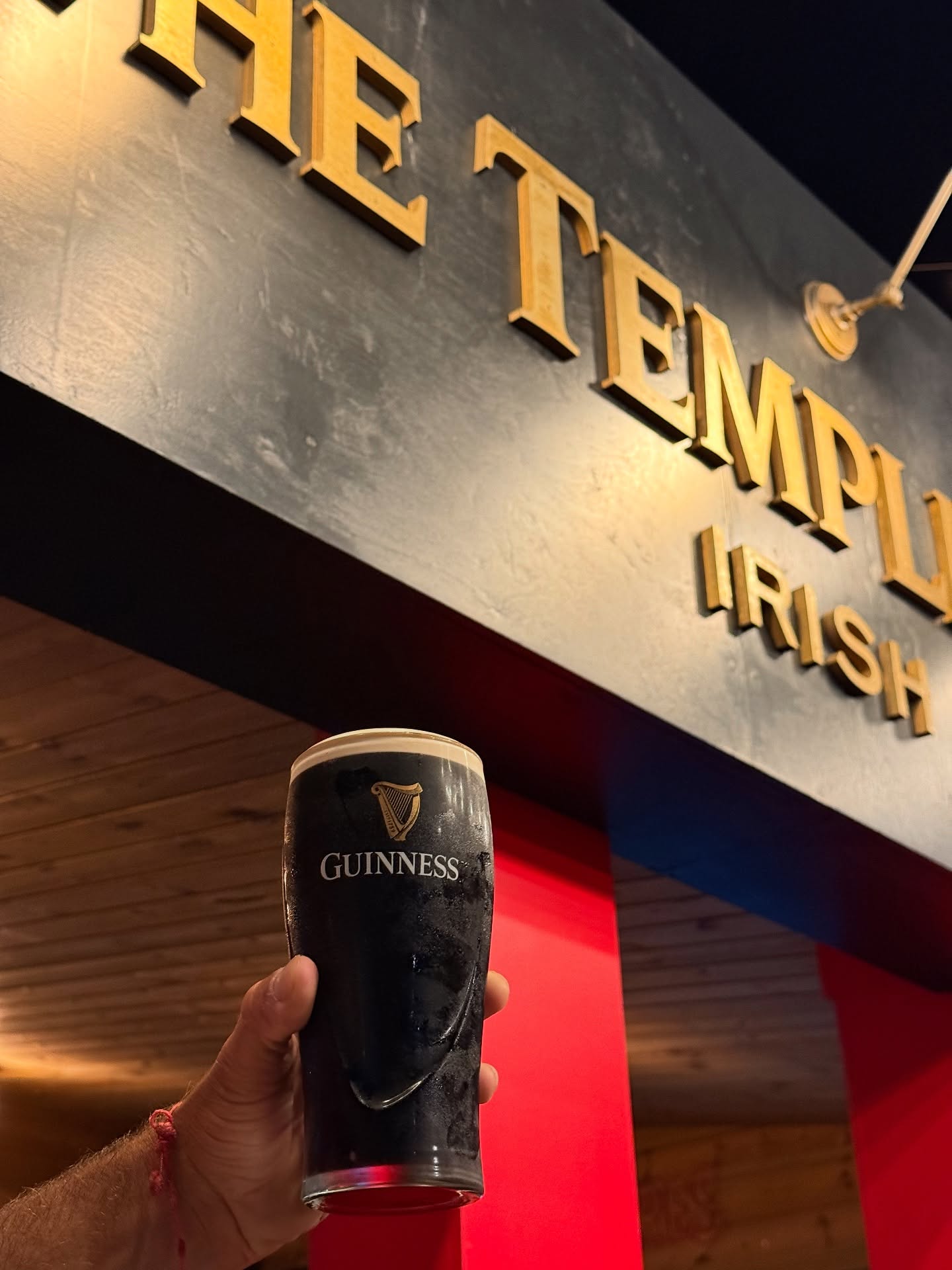 Guinness raised in front of The Temple Corner sign